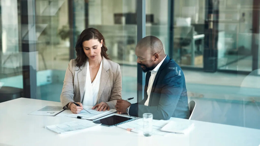Real estate agent reviewing documents with a client to ensure real estate compliance in Queensland