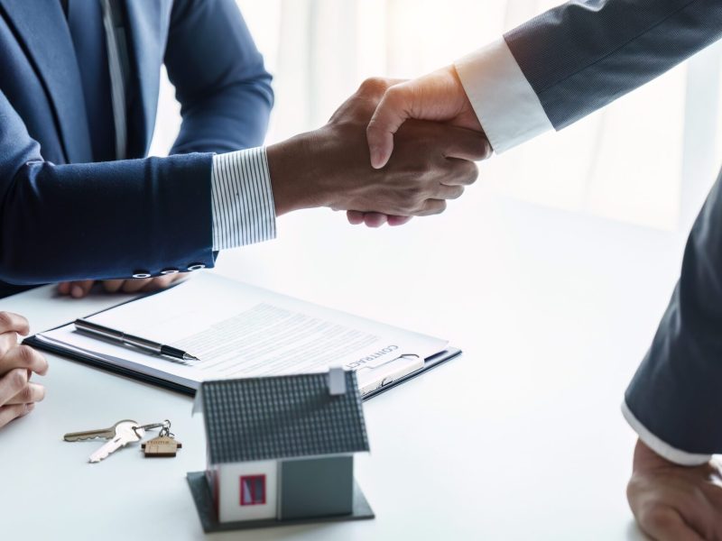 Close up of A businessman buys a house and shakes hands after the transaction. Having a conversation with a real estate agent.